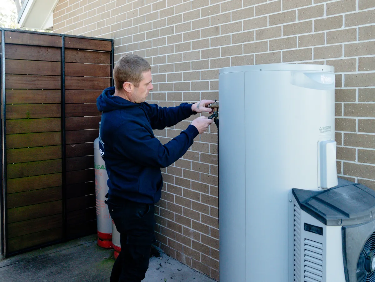 Plumber servicing a Rheem hot water system